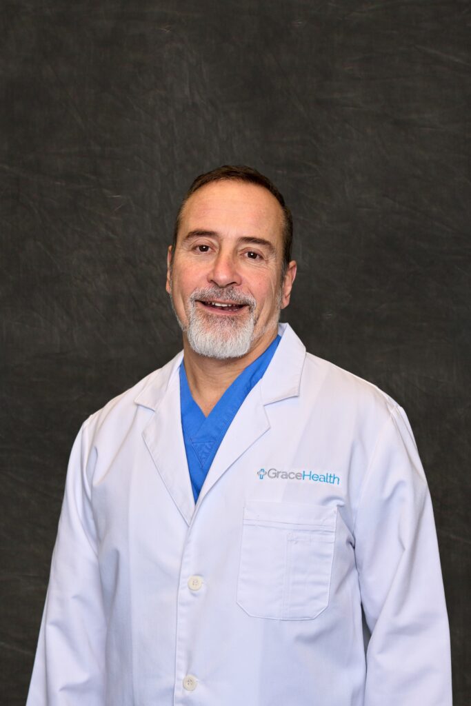 A professional headshot of Enrico Ascani, a man with a friendly smile, wearing a white medical coat.