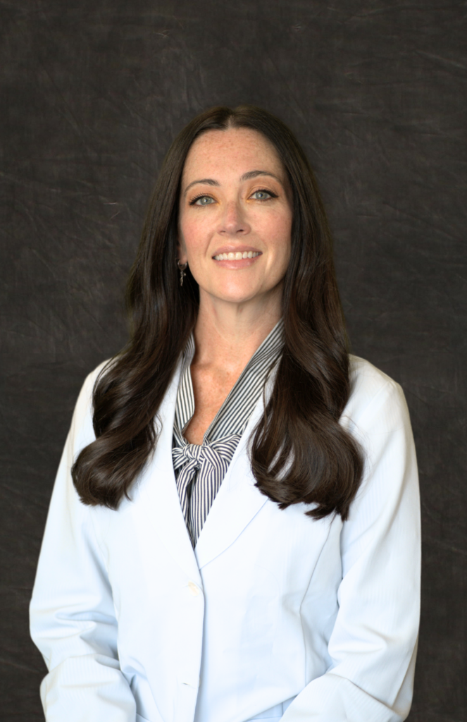 Ashlee Robinson, MD, a family practice doctor at Grace Health, smiles while wearing a white lab coat.
