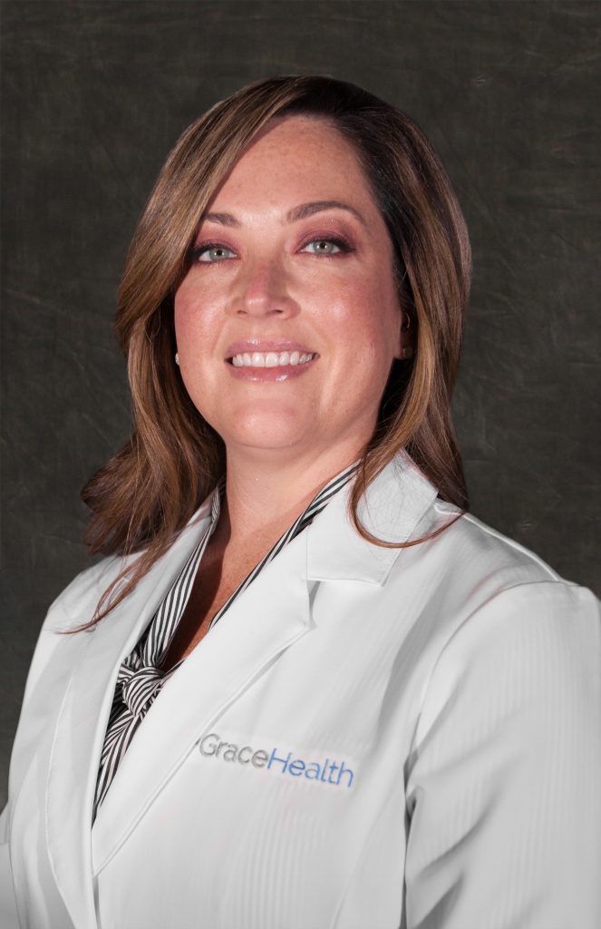 Ashlee Robinson, MD, a family practice doctor at Grace Health, smiles while wearing a white lab coat.